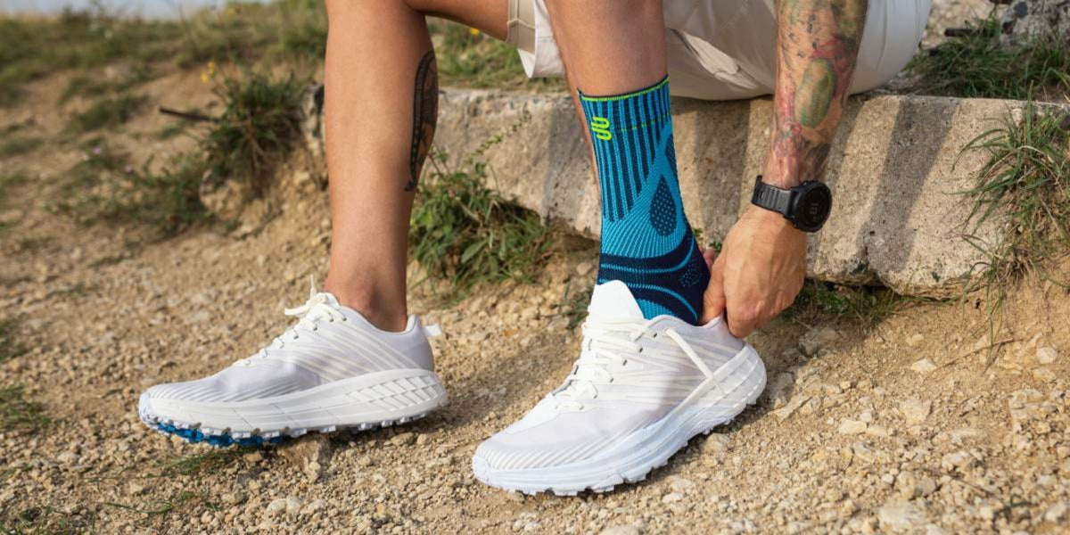Kannst du mir dieses Bild etwas nachschärfen? Es zeigt eine Wanderin beim Wandern mit einer Sprunggelenkbandage.